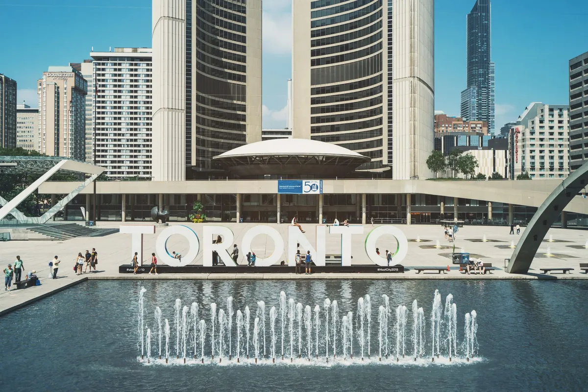 Large TORONTO letters and a fountain in front of two curved office towers