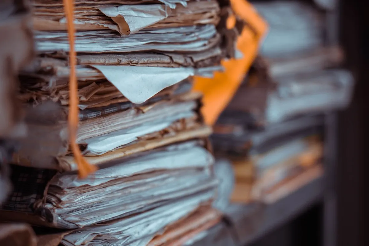 Stacked case files tied with string on a shelf